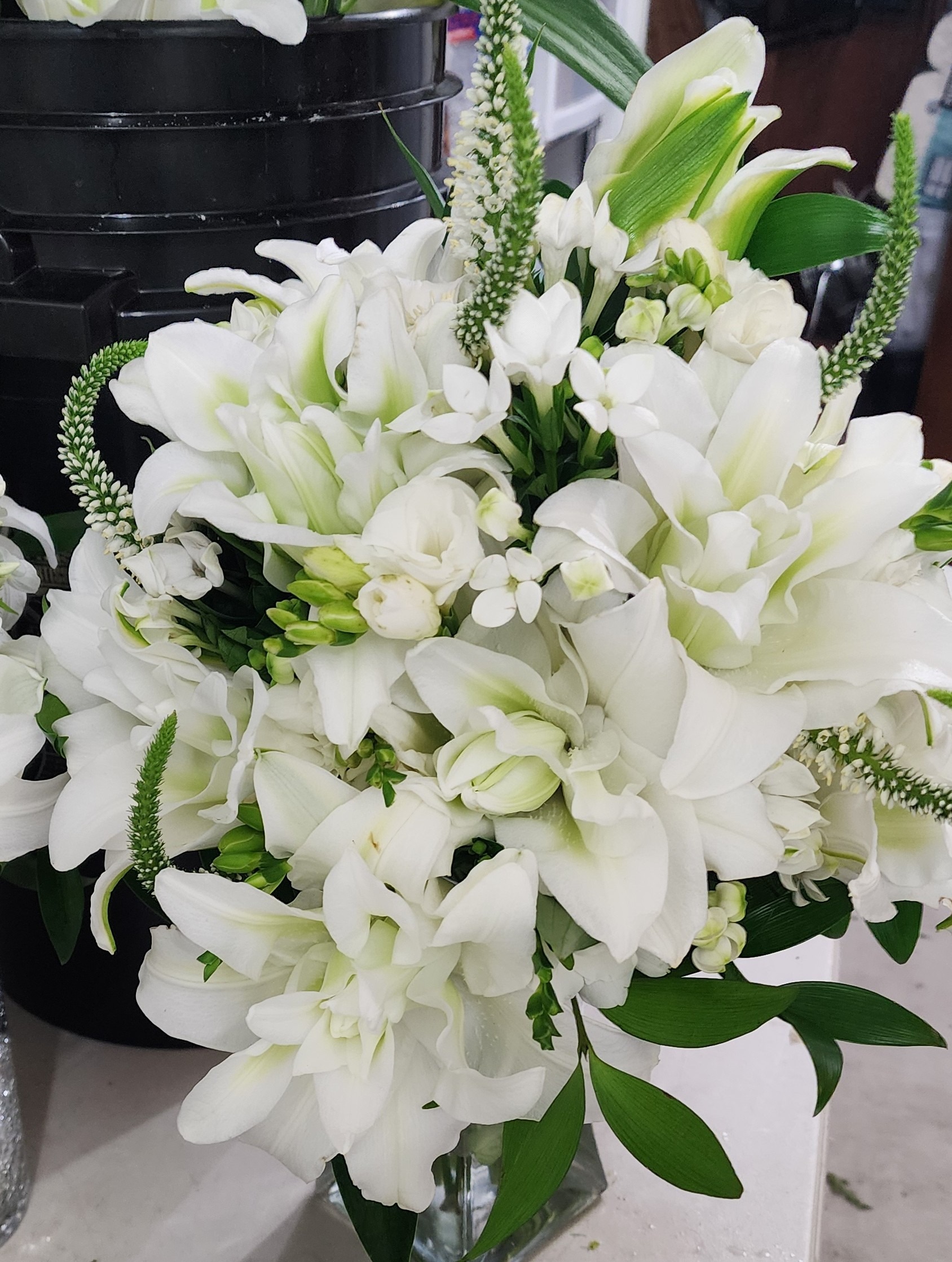 Elegant bouquet of white lilies and delicate flowers, showcasing lush greenery, ideal for weddings or floral arrangements.